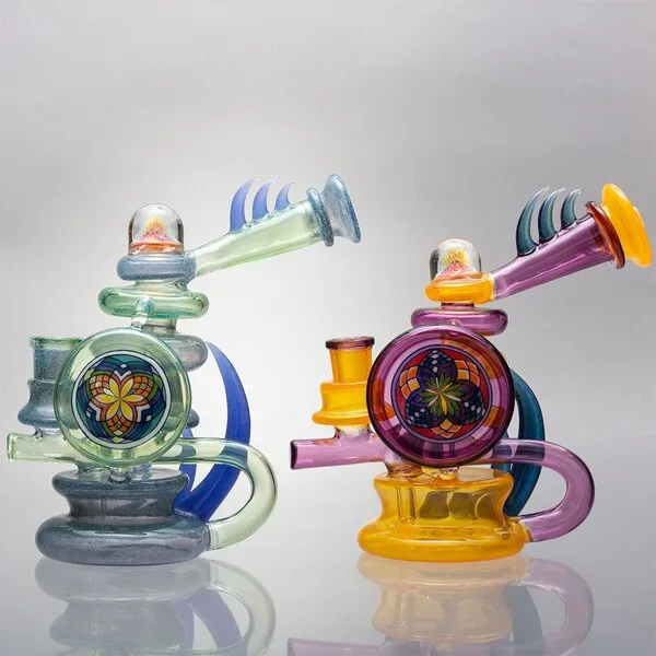 Two vibrant glass art rigs with intricate flower mandala designs, green and purple.
