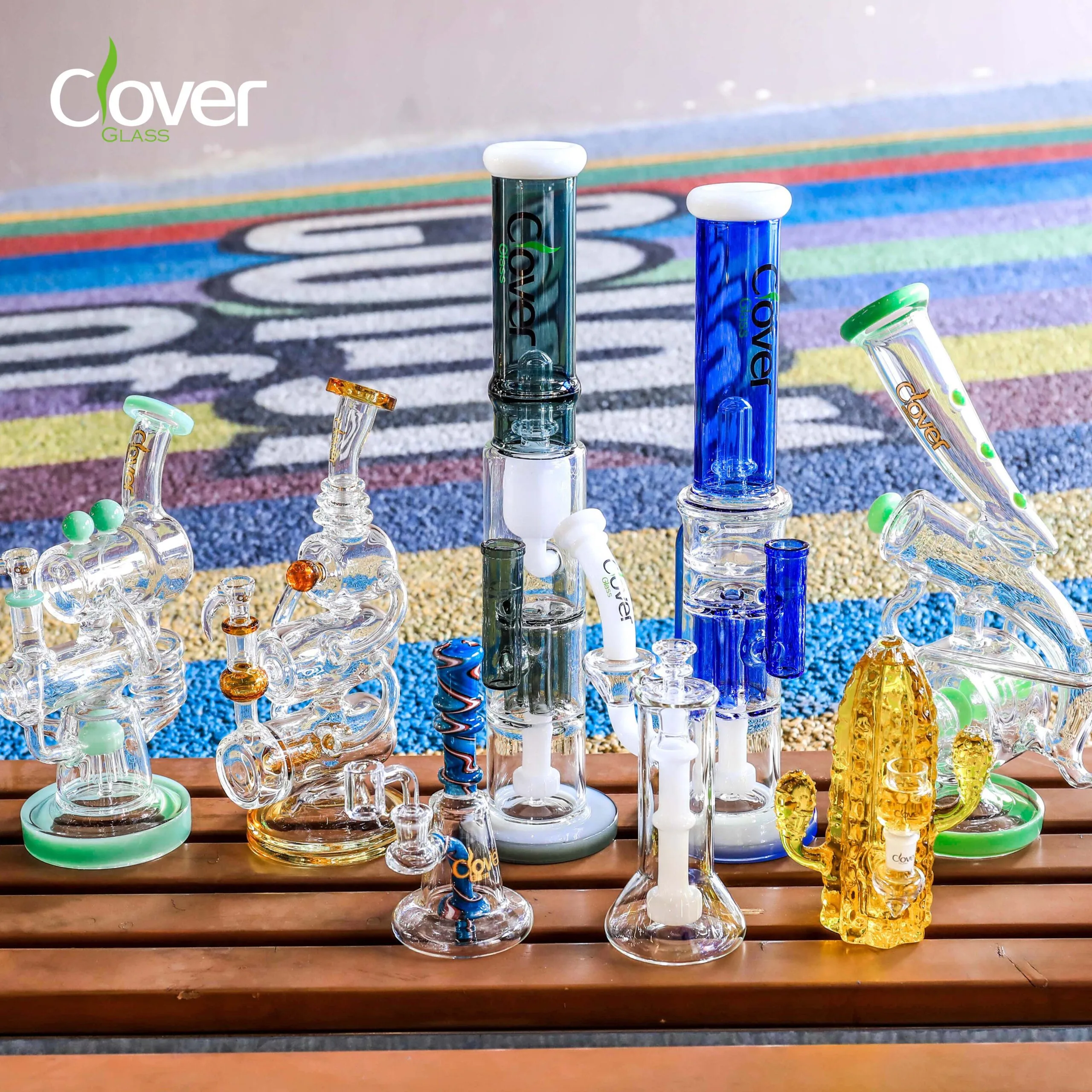 Diverse collection of Clover Glass bongs, water pipes, and smoking accessories.