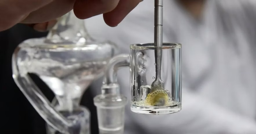 Close-up of quartz banger with dab tool melting concentrate inside glass rig
