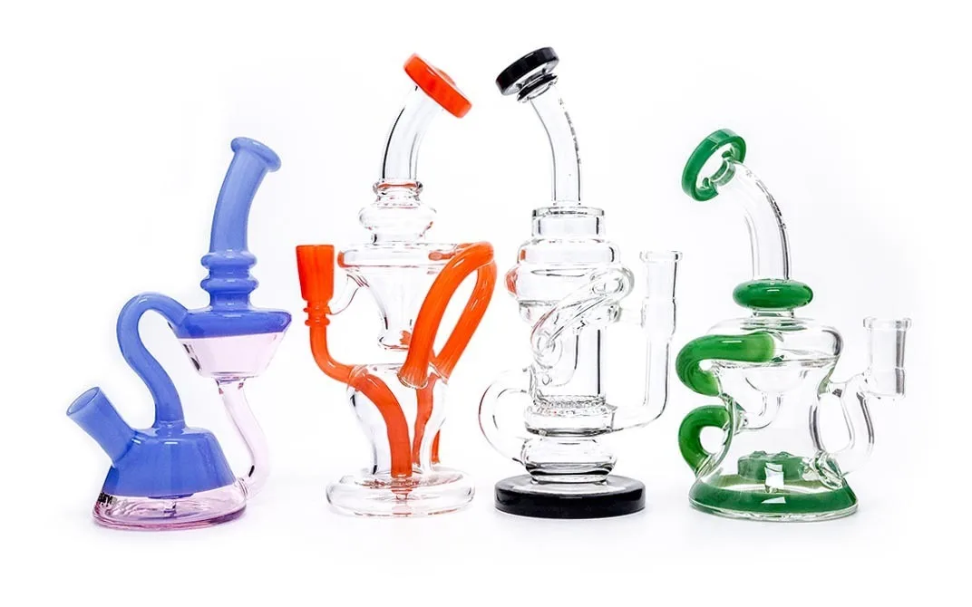 A collection of four colorful glass dab rigs with unique, intricate percolator designs.