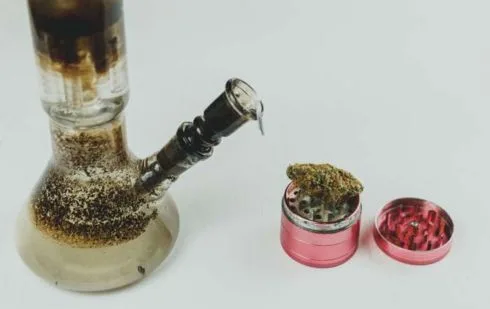 Dirty <a href="https://cloverglasspipe.com/traveling-with-glass/"  data-wpil-monitor-id="9524">bong water inside a clear glass water pipe</a> chamber with visible residue and cloudy discoloration