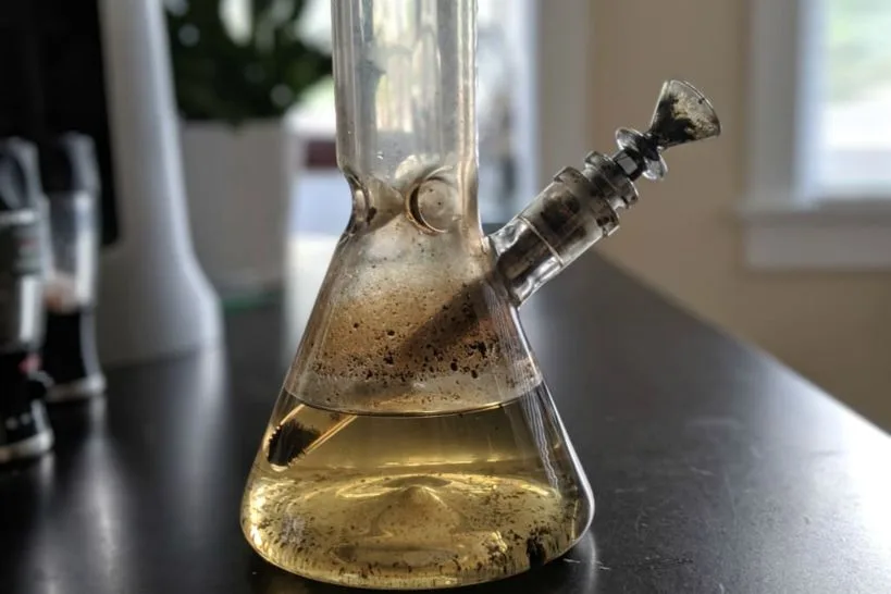 close up dirty bong water residue particles floating