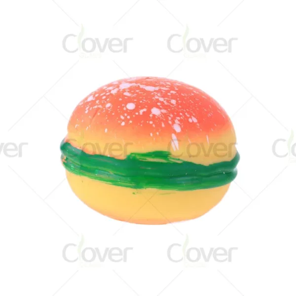 Colorful hamburger-shaped bath bomb with orange, green, and yellow layers.