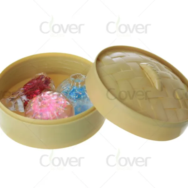 Miniature beige steamer box with lid open, revealing three colorful glass bottles.